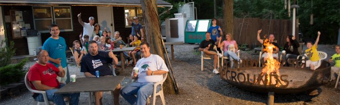 Camper's enjoying themselves in front of the campfire at Rip Van Winkle Campgrounds