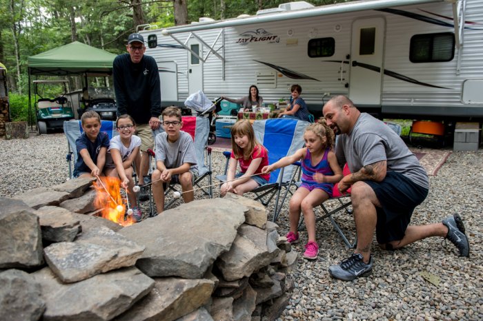 Family gathered at campfire at Rip Van Winkle Campgrounds located in the Catskills NY