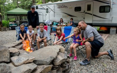 Family gathered at campfire at Rip Van Winkle Campgrounds located in the Catskills NY
