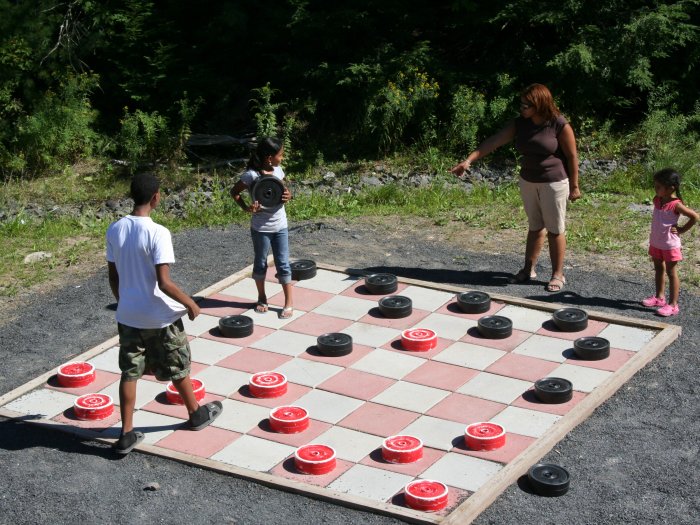 Kids playing on top of a giant checker board