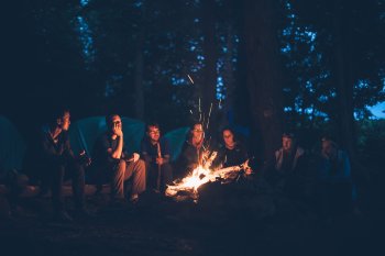 group of campers gathered around the fire at Rip Van Winkle Campgrounds in the Catskills NY