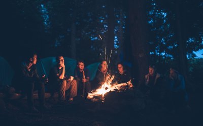 group of campers gathered around the fire at Rip Van Winkle Campgrounds in the Catskills NY