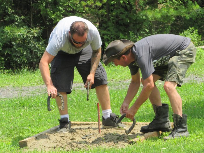 2 men measuring horseshoe distances